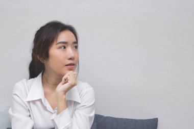 Düşünceli Asyalı kadın beyaz kopyalama alanı arka plan ile yeni fikir düşünüyorum.