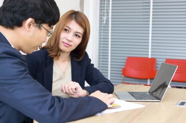 Çekici genç Asya yatırım danışmanı iş kadını müvekkiline tartışıyor.