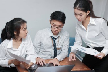 Takım çalışması konsepti. Modern ofiste dizüstü bilgisayarla çalışan bir grup Asyalı. Seçici odak ve alanın sığ derinliği.