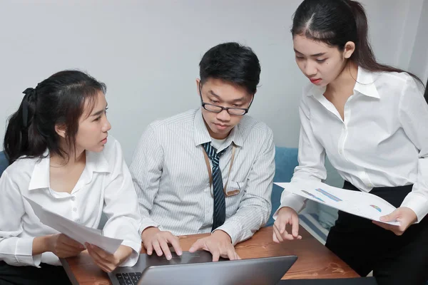 Концепция командной работы. Группа азиатских людей, работающих с ноутбуком вместе в современном офисе. Селективная фокусировка и мелкая глубина резкости . — стоковое фото