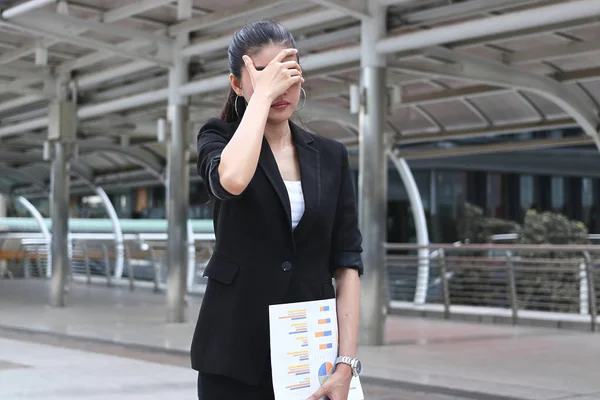 Nedstämd stressad ung asiatisk affärskvinna som täcker ansiktet med händer som lider av problem — Stockfoto