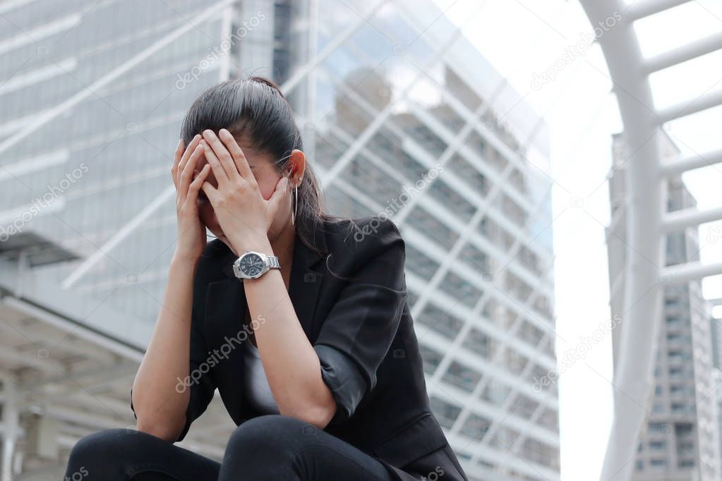 Depressed stressed young Asian business woman covering face with hands suffering from trouble