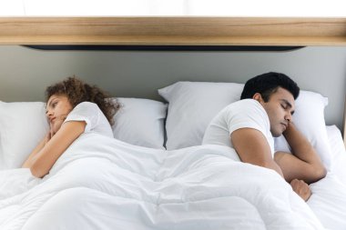Sinirli stresli genç çift yatakta birbirlerine sırtlarını yatarken. İlişki ve sorunlar çiftler kavramı.