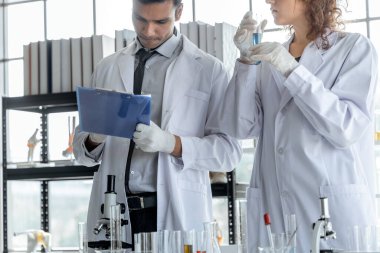 Genç bir bilim adamı modern kimya laboratuarında kimyasalları inceliyor. Bilim ve tıp konsepti