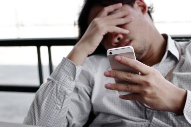 Depresyondaki işsiz Asyalı adam evde oturuyor. Başarısızlık ve işten çıkarma kavramı.