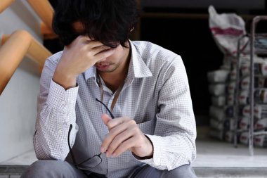 Depresyondan muzdarip Asyalı genç iş adamı hayal kırıklığına uğradı. İşsizlik ve işten çıkarma kavramı.