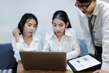 Ofiste birlikte çalışan bir grup Asyalı iş adamı. İş ekibi işbirliği ortaklık kavramı.