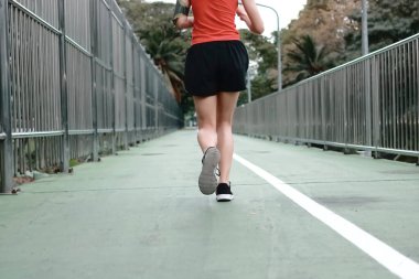 Sokaklarda koşan sağlıklı genç koşucunun arka görüntüsü. Fitness ve egzersiz konsepti.