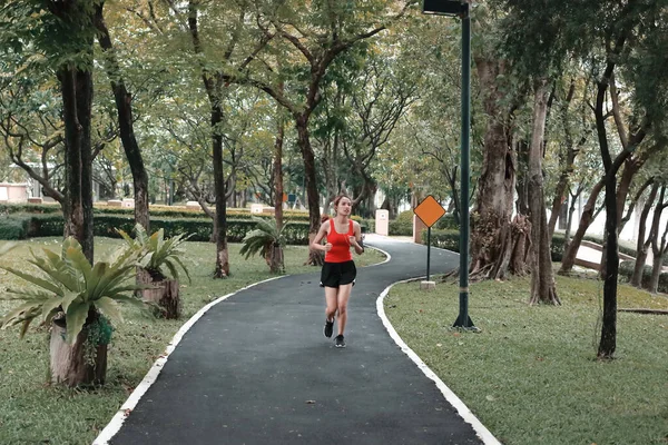 음악을 공원에서 운동을 활기넘치는 아시아 달리기 — 스톡 사진