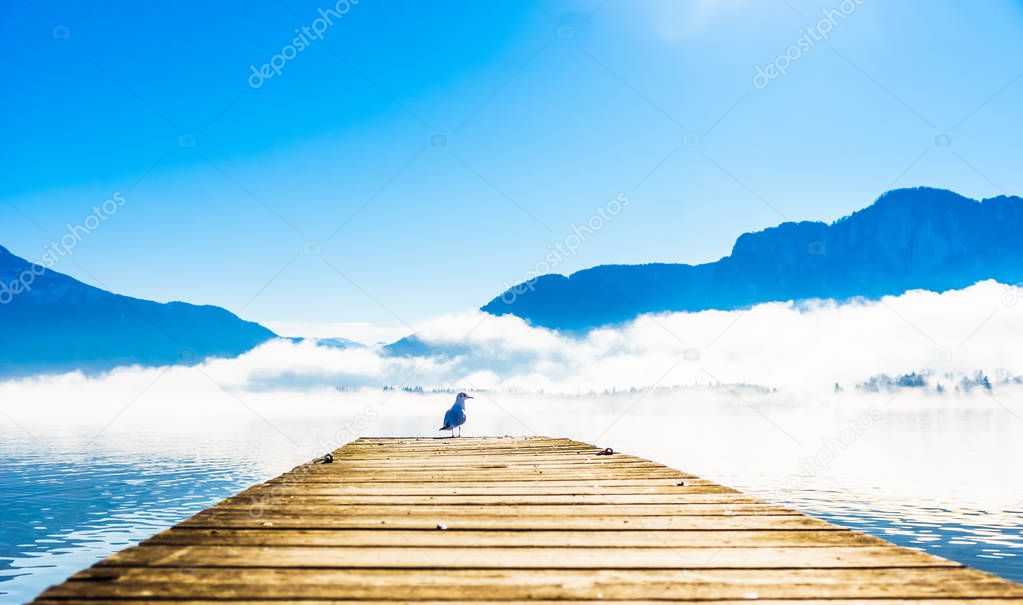 View on morning fog on Pier of lake Mondsee and Alps in Austria