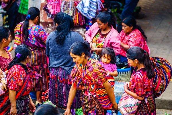 Chichicastenango, Guatemala üzerinde 2 Mayıs 2016: bebek kendi arka Chichicatenango piyasada yerli maya kadın grup üzerinde görünümü