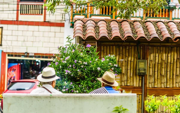 People of Colombia, group of old man sitting on bench in the colorful streets of Filandia Village