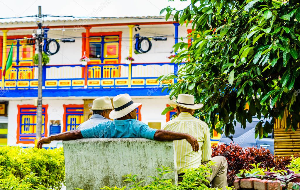 People of Colombia, group of old man sitting on bench in the colorful streets of Filandia Village