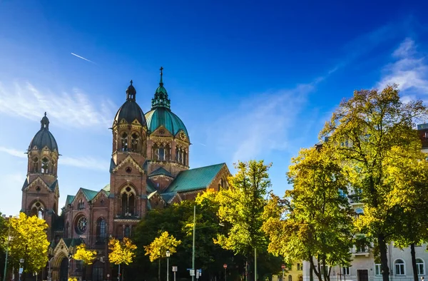 Isar och höst landskap nerxt till Sankt Lukas kyrka i München, Bayern, Tyskland — Stockfoto