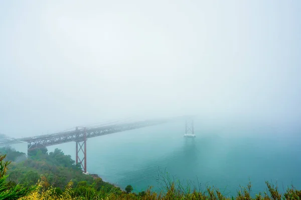 Vista de la niebla en el Ponte 25 de Abril es un puente colgante sobre el río Tejo, Portugal — Foto de Stock