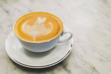 Sıcak latte sanat mermer masada kahve fincan.