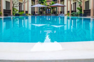 Otel havuzunda 2 şemsiye.