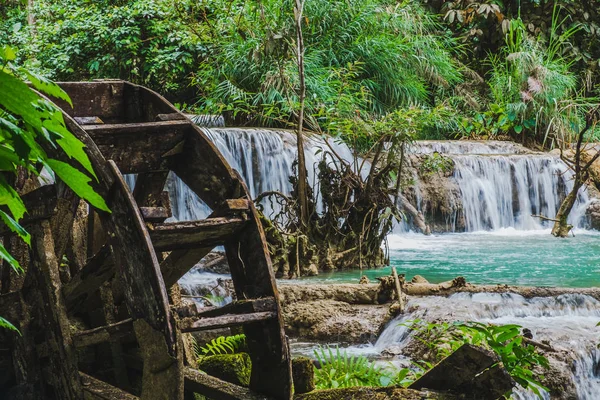 Kuang Si 'nin suyu eski bir çarkla dökülüyor, Laos.