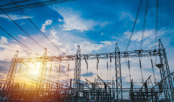 Sunset behind substation towers with blue sky