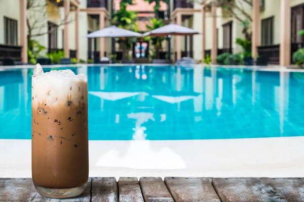 Segelas kopi es di meja kayu dekat kolam renang — Stok Foto