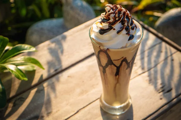 Frappe kopi dengan krim kocok di meja kayu tua di pagi hari — Stok Foto