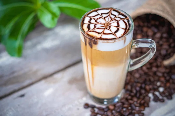 Hot latte kopi macchiato dengan seni sirup cokelat — Stok Foto