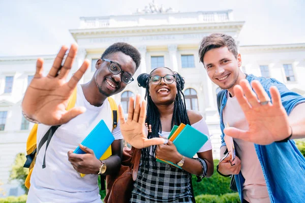 Vacances d'été, éducation, campus et concept d'adolescent - groupe d'étudiants ou d'adolescents multiethniques agitant la main sur le bâtiment universitaire . — Photo