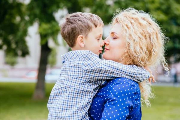 Mam en jongen buiten. Moeder knuffel kleine zoon met ware liefde. Vrouw met kind. Mothers Day concept. Gelukkige familie geniet van de zonnige dag in de zomer. Liefde zorg en vertrouwen concept. — Stockfoto