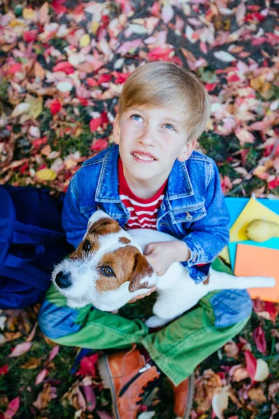 Jongen knuffelende hond in de herfst — Stockfoto