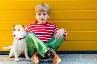 Mutsuz, küçük çocuk köpeği Jack Russell Terrier ile yerde yatıyor.