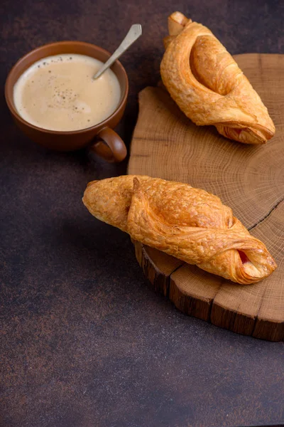 Lezzetli breakfast kruvasan ve kahve Kupası ile. Koyu kahverengi zemin