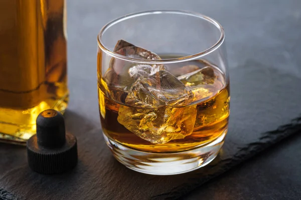 暗い石の背景にキューブとクローズアップウイスキーグラス — ストック写真