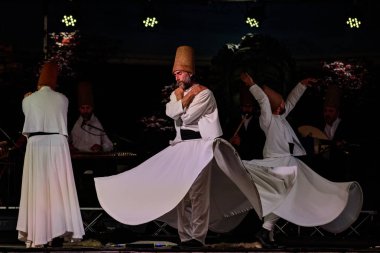 The Turkish whirling dancers or Sufi whirling dancers performing of the Mevlevi (whirling dervish) sema  at the festival LO SPIRITO DEL PIANETA clipart