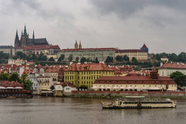 Hradcany Prag Kalesi ve yağmurlu bir gün, yatay görüntü Çek Cumhuriyeti başkenti Vltava Nehri üzerinde bir tekne görünümü