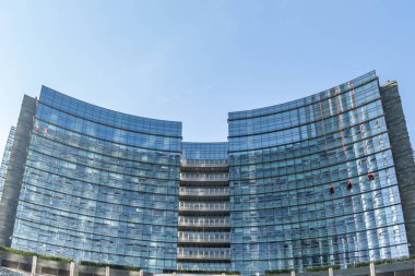 Üç işçiler temiz pencere eşiği Milan ' ın büyük bir gökdelenin erkeklerin binanın dışında bir çift ip bağımlısı iş yerinde çalışmak