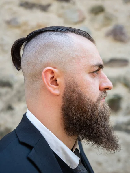 Uzun sakallı ve kısa saçlı şık elbiseli bir adamın portresi.