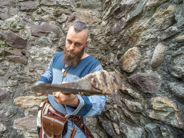 石壁の前に斧を振りかける若いバイキングの肖像画 屋外に設置された肖像画 — ストック写真
