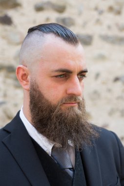 Profile portrait of a man with a long beard and a short haircut in elegant clothes clipart