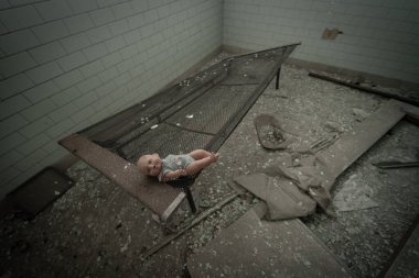 A vintage doll abandoned in the rooms of an abandoned psychiatric facility, urbex image clipart