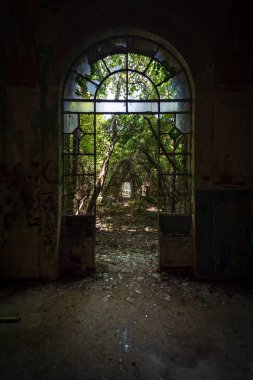 Yirminci yüzyılda yıkık dökük bir İtalyan binasının camları olan kemerli kapı, Urbex resmi.