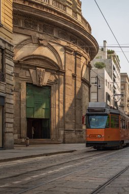 Bir İtalyan şehrinin sokaklarında bir tramvay bir kilisenin önünde, Milan 'da sokak fotoğrafçılığı yapıyor.