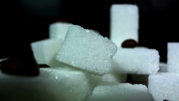 Куча кусочков сахара вращается на черном фоне — стоковое видео