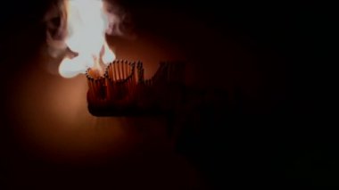 Siyah arka plan üzerinde seri olarak birer birer ışıklı maçlar.