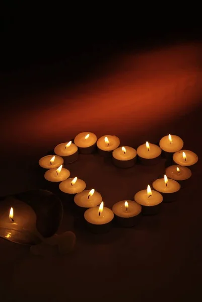 Kalp siyah bir arka plan üzerinde mumlar yapılmış.