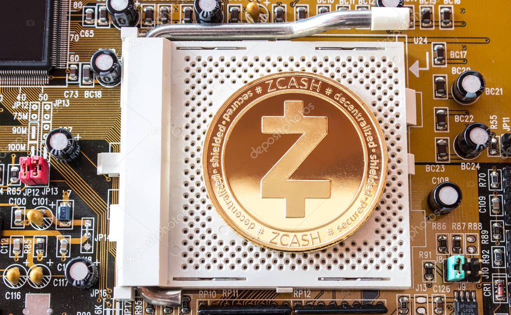 On a motherboard is front side of gold coin of a digital crypto  currency - zcash. 