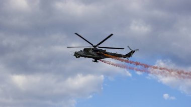 Helikopter ile beyaz bulutlar mavi gökyüzü üzerinde kırmızı duman ile mücadele. Alttan görüntülemek. 