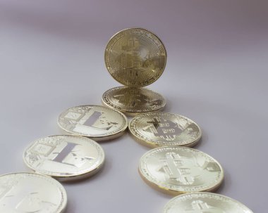 Gri bir arka plan üzerinde gümüş para birimlerinin bir dijital kripto - Litecoin ve Bitcoin vardır. Yalancı sikke ek olarak bir ayakta bitcoin işte.