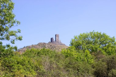 Ceske Stredohori Dağları 'nın tepesindeki Hazmburk Kalesi kalıntıları. Meyve ağaçları ve mavi gökyüzü.