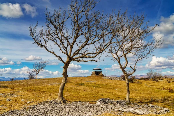 O cogumelo na cicatriz de escuteiro, Kendal, emoldurado por árvores de cinzas . — Fotografia de Stock