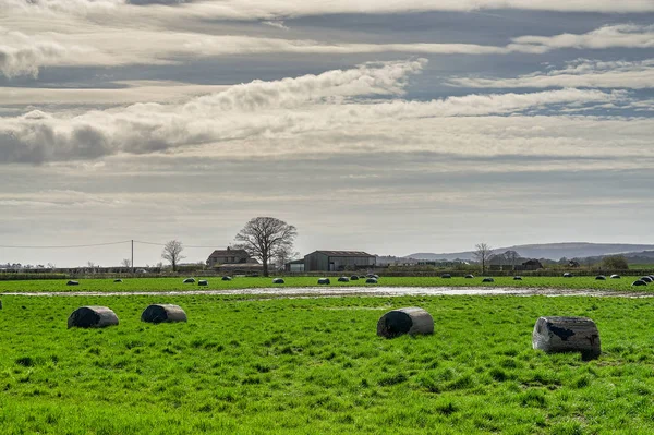 在一片多云的天空下 英国农场裹着一捆干草 — 图库照片